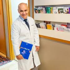 Dr. Moiin holding his dermatology atlas